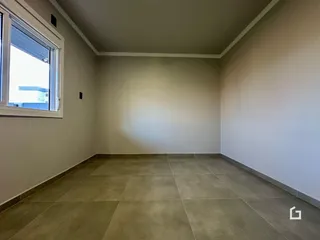 Ambiente interno de uma sala com piso de cerâmica e janela em um imóvel em Lajeado.
