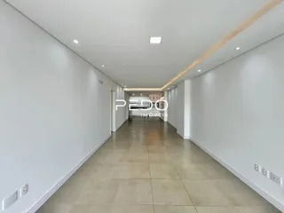 Corredor interno de um imóvel com paredes brancas e piso de cerâmica.