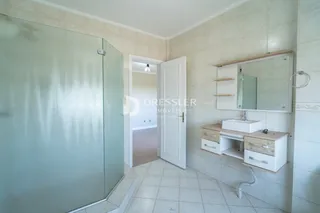Foto de um banheiro com piso cerâmico e armário de bancada.