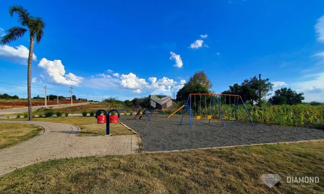 Vista externa de uma área gramada com um playground ao ar livre.