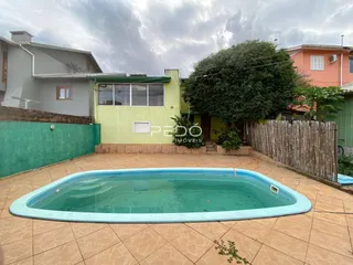 Foto da fachada de uma casa com piscina e muro de madeira em Lajeado, Brasil.