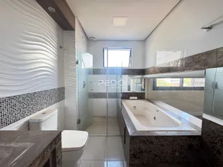Banheiro moderno com box de vidro e banheira em um ambiente de alto padrão.