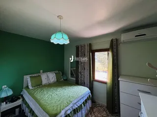 Quarto com cama e janela em sala de estar.