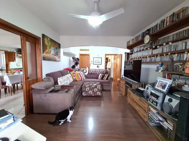 Sala de estar com piso de madeira e estantes de livros.