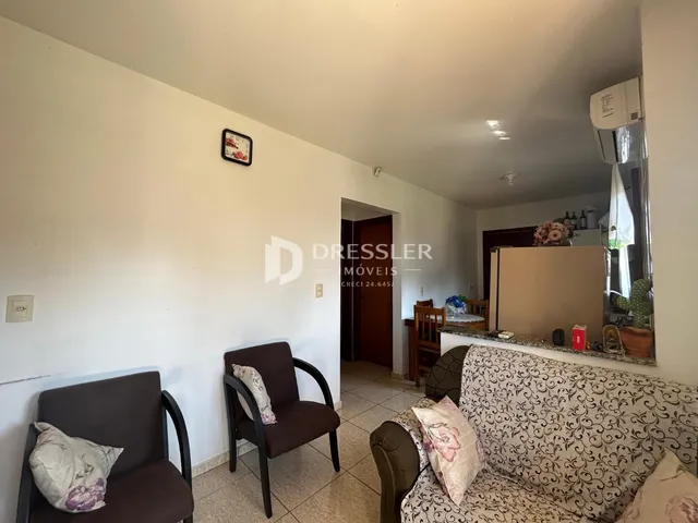 Sala de estar com sofá e cadeiras em um imóvel no Brasil.