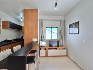 Sala de estar com cozinha integrada em imóvel no Brasil.