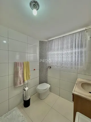 Foto interna de um banheiro com revestimento cerâmico nas paredes.