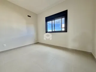 Ambiente interno de uma sala com piso de cerâmica e janela grande.