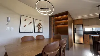 Foto de uma sala de jantar com mesa de madeira e cadeiras de couro.