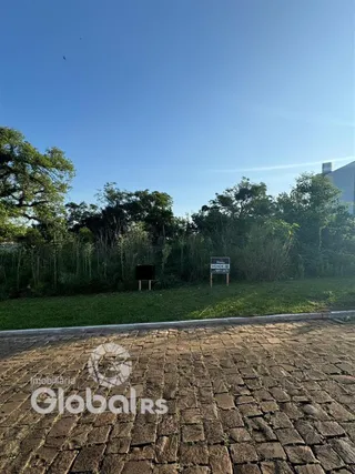 Vista externa de uma propriedade com gramado e pavimento.