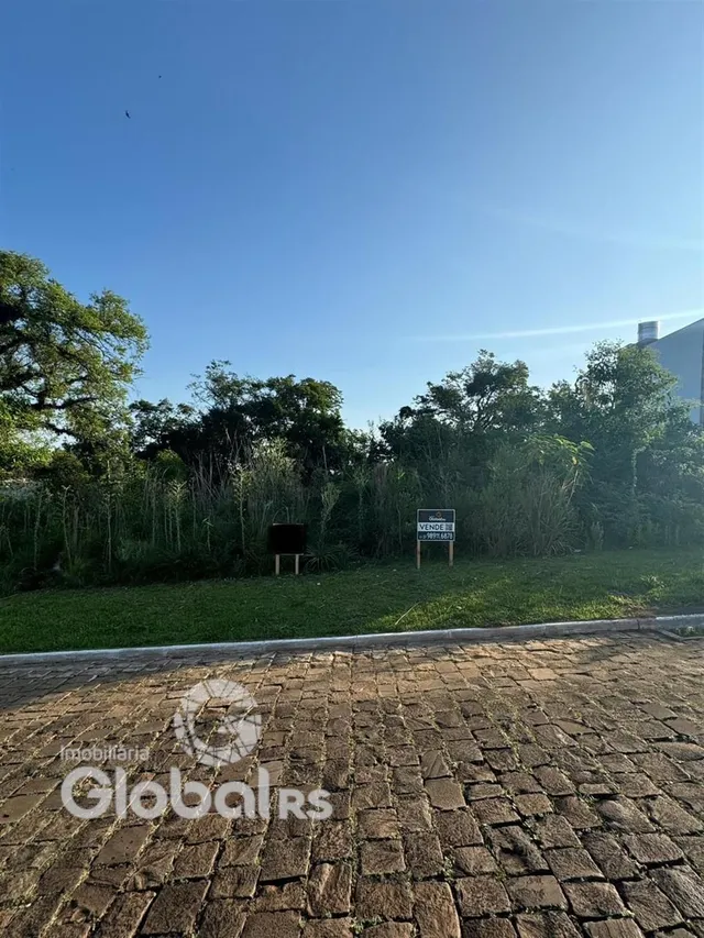 Vista externa de uma propriedade com gramado e pavimento.
