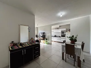 Ambiente interno de uma sala de estar com área de jantar e cozinha em um imóvel no Brasil.