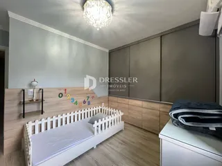 Quarto com cama de madeira e piso de madeira clara em um imóvel no Brasil.