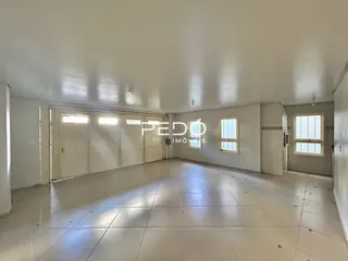 Ambiente interno amplo com piso claro e teto branco.