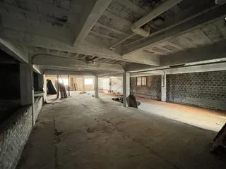 Espaço interno de construção com estrutura de concreto aparente.