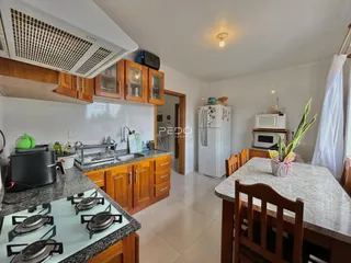 Cozinha com armários de madeira e bancadas em um imóvel no Brasil.