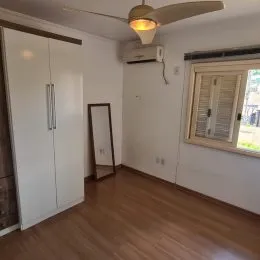 Ambiente interno com paredes brancas e piso de madeira.