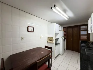 Interior de uma sala com piso de cerâmica e mesa de madeira.