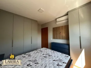Quarto com armários embutidos e cabeceira de cama.