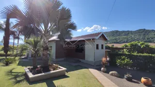 Fachada de uma casa em Lajeado, Brasil, com paisagismo verde e palmeiras.