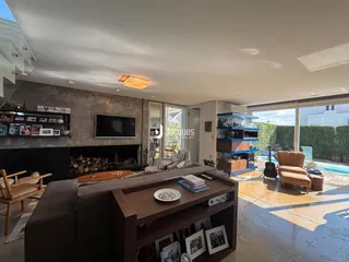 Sala de estar com lareira e vista para o exterior da residência.