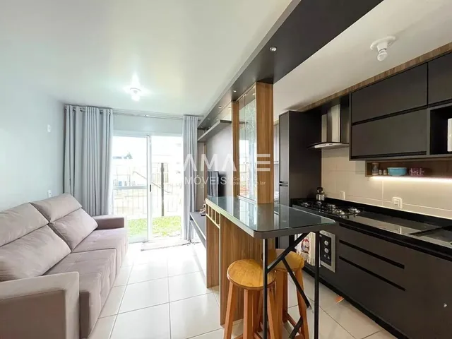 Sala de estar e cozinha com vista para o exterior.