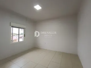 Foto de um cômodo interno com piso claro e janela.