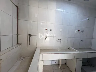 Parede com revestimento cerâmico e estrutura de bancada em um ambiente interno.