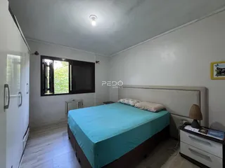 Quarto com cama e armário em ambiente interno.