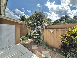 Fachada de uma residência com jardim e muro de alvenaria.