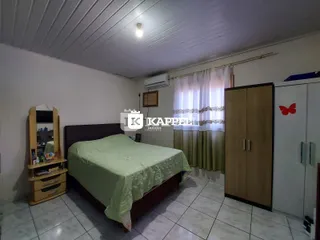 Quarto com cama de casal, cabeceira e guarda-roupa de madeira.