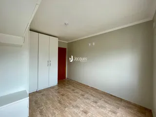 Interior de um ambiente com paredes brancas e piso de cerâmica.