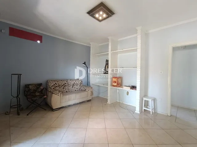Sala de estar com sofá e piso de cerâmica em um imóvel no Brasil.