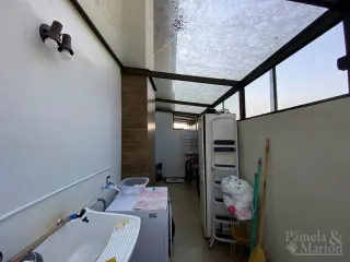 Foto de um banheiro mostrando uma banheira e um refrigerador branco.