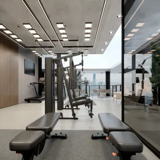 Imagem de um espaço moderno com equipamentos de ginástica e grandes janelas.