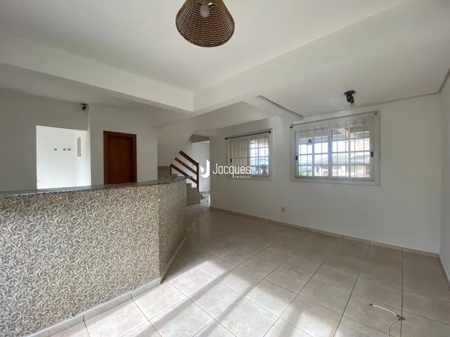 Hall de entrada com piso de cerâmica e parede decorada em Lajeado.