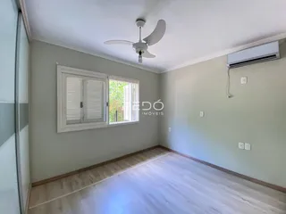 Sala de estar com piso de madeira clara e janela.