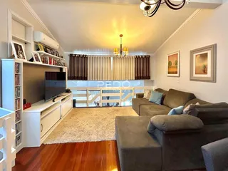 Sala de estar com sofá e estantes de madeira.