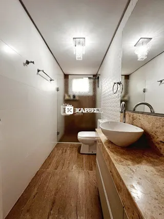 Foto de um banheiro com bancada de mármore e piso de madeira.