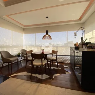Uma sala de jantar com mesa redonda e grandes janelas.
