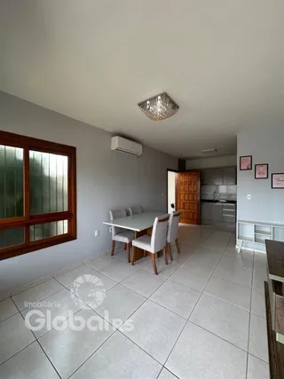 Uma sala de jantar com mesa e cadeiras em um imóvel.