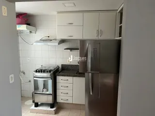 Cozinha com armários brancos e revestimento de cerâmica.