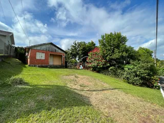 Fachada de uma casa de tijolos vermelhos com gramado em Lajeado, Brasil.
