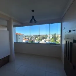 Sala de estar com grande janela oferecendo vista da cidade.