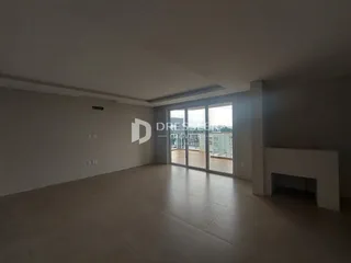 Ambiente interno de uma sala com piso claro e porta de vidro.