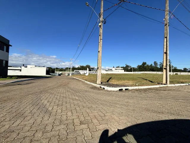 Vista externa de uma propriedade com área pavimentada e postes de luz.