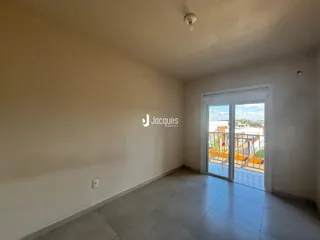 Interior de uma sala com piso de cerâmica e porta de vidro abrindo para o exterior.
