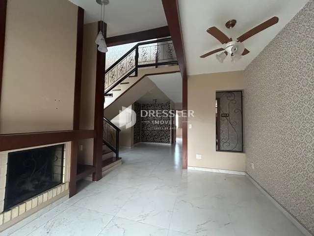 Hall de entrada com escadaria e lareira em um imóvel no Brasil.
