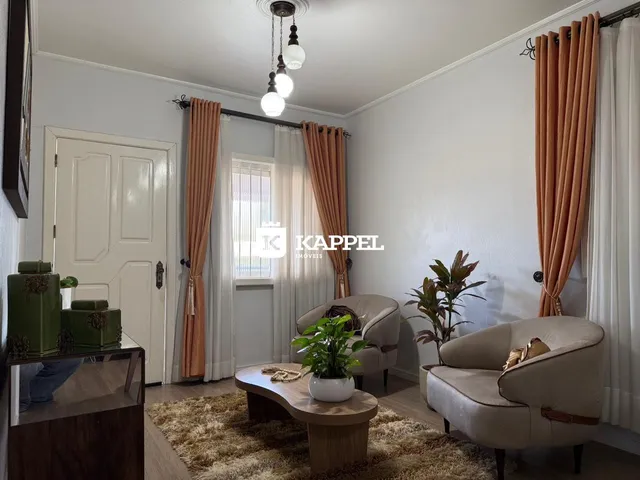 Foto de uma sala de estar com sofá e cortinas.