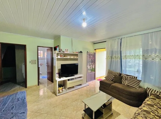 Foto de uma sala de estar com sofá e televisão.
